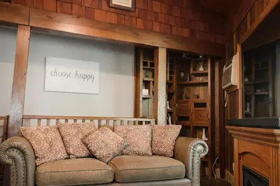 a couch sitting in a living room with a fireplace at Spacious 3 Plus 1 Bedroom 2 Bath Cottage Retreat with Fire Pit and Pool Table in Brighton