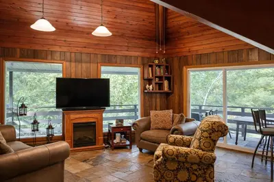 a living room with a fireplace and a flat screen tv at Spacious 3 Plus 1 Bedroom 2 Bath Cottage Retreat with Fire Pit and Pool Table in Brighton