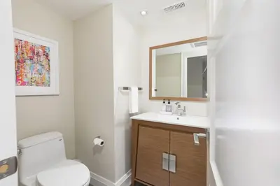 a bathroom with a toilet and a sink and a mirror at Steps to Blue Mtn Condo wt Elegant Style 213 Sierra Lane in Blue Mountains