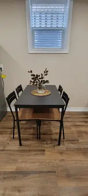 a black table with chairs and a plant on it at Guest Suite in Whitby in Whitby