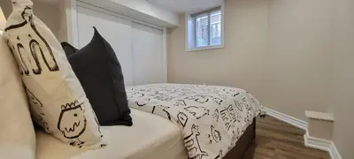 a bedroom with a bed with black and white sheets and pillows at Guest Suite in Whitby in Whitby