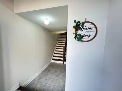a hallway with a stairway with a sign on the wall at Beautiful Vacation Home near Toronto Airport in Mississauga