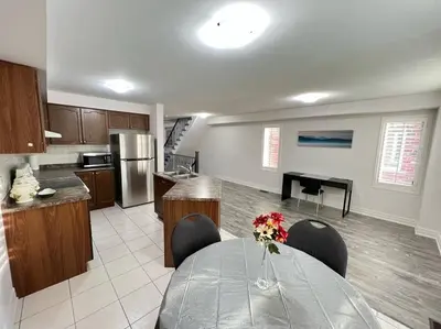 a kitchen with a table with chairs and a kitchen with a tableablish at Beautiful Vacation Home near Toronto Airport in Mississauga