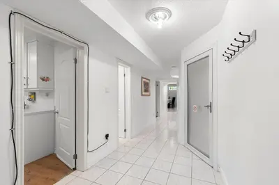 a hallway with two white doors and a tile floor at Home Away From Home in Richmond Hill