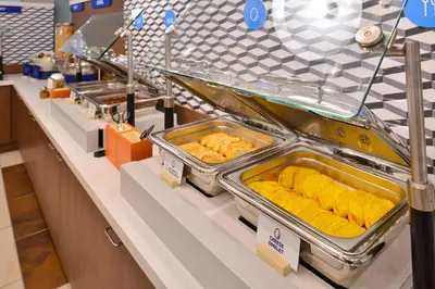 a buffet line with trays of food on display at Holiday Inn Express & Suites Toronto Airport South by IHG in Toronto