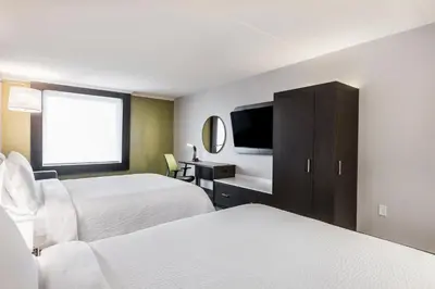 a hotel room with two beds and a flat screen tv at Holiday Inn Express & Suites Toronto Airport South by IHG in Toronto