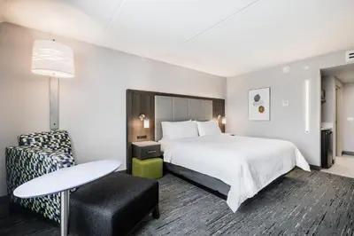 a hotel room with a bed and a table and a chair at Holiday Inn Express & Suites Toronto Airport South by IHG in Toronto