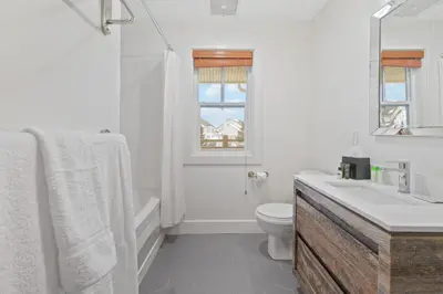 a white bathroom with a toilet and a sink at Rivergrass Home with Mountain and Golf Course Views in Blue Mountains