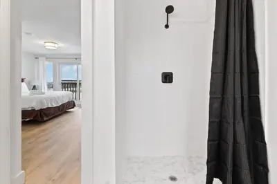a white bedroom with a bed and a shower at Rivergrass Home with Mountain and Golf Course Views in Blue Mountains