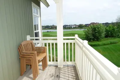 a porch with a chair and a view of a golf course at Rivergrass Home with Mountain and Golf Course Views in Blue Mountains