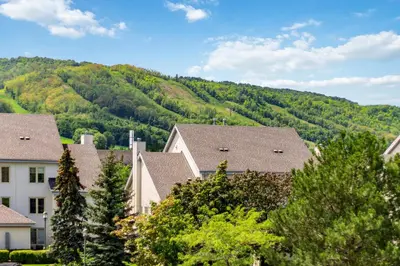 a group of houses in front of a mountain at Rivergrass Home with Mountain and Golf Course Views in Blue Mountains