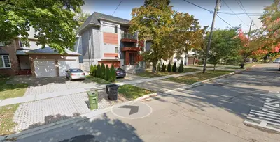 an empty street with a parking meter in front of a house at Modern House in Toronto in Toronto