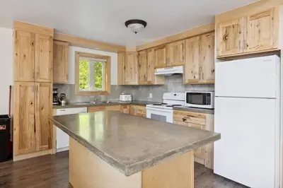 a kitchen with wooden cabinets and a white refrigerator at 10 Bedroom Executive Chalet w Hot Tub in Blue Mountains