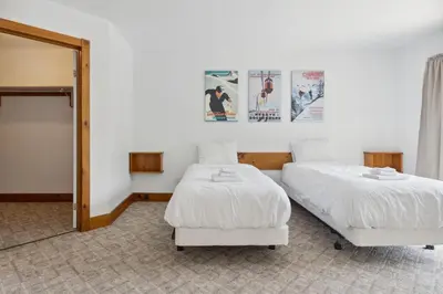 a bedroom with two beds and a mirror at 10 Bedroom Executive Chalet w Hot Tub in Blue Mountains