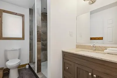 a bathroom with a toilet and a sink and a mirror at 10 Bedroom Executive Chalet w Hot Tub in Blue Mountains