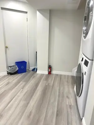 an empty living room with a washer and dryer at Perfect location comfort private house lower level 2 bedroom unit in Mississauga