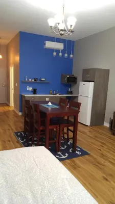 a kitchen with a table and chairs and a blue wall at Canalside Restaurant & Inn in Port Colborne
