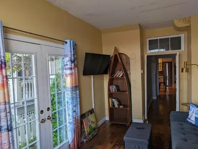 a living room with a tv and a book shelf at Canalside Restaurant & Inn in Port Colborne