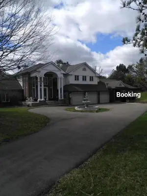 a large white house with a driveway at Lakeview private suite-Twin or king in Tottenham