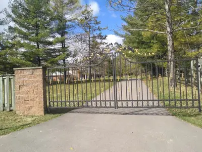 a black metal gate with a stone pillar at Lakeview private suite-Twin or king in Tottenham