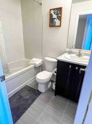a bathroom with a white toilet and a sink at NEWLY BUILT LUXURIOUS 3BRM TOWN HS/AIRPORT/PARKING in Brampton