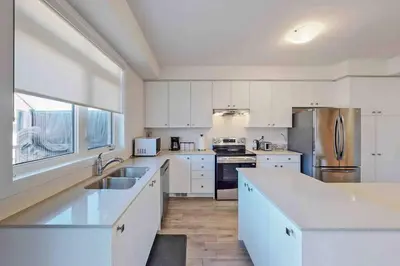 a kitchen with white cabinets and stainless steel appliances at NEWLY BUILT LUXURIOUS 3BRM TOWN HS/AIRPORT/PARKING in Brampton