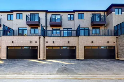 a large brick building with two garage doors at NEWLY BUILT LUXURIOUS 3BRM TOWN HS/AIRPORT/PARKING in Brampton