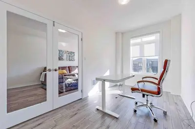 a white room with a desk and a chair at NEWLY BUILT LUXURIOUS 3BRM TOWN HS/AIRPORT/PARKING in Brampton
