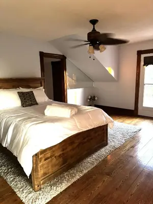 a bedroom with a bed and a ceiling fan at Farmhouse Resort in Midhurst