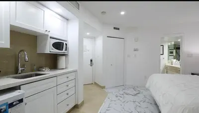 a white kitchen with a bed and a sink at Carriage Hills Retreat Rental in Edgar
