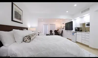 a white bedroom with a large bed and a kitchen at Carriage Hills Retreat Rental in Edgar