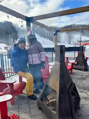 two people sitting on a bench next to a fireplace at Carriage Hills Retreat Rental in Edgar