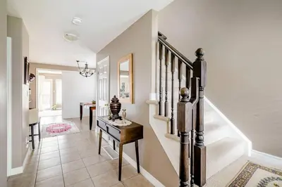 a hallway with stairs and a table in a house at Nimo Homestay in Guelph