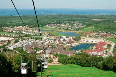 a gondola ride over a town and a lake at Condo 204 at North Creek Resort in Blue Mountains