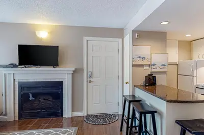 a living room with a fireplace and a tv on a wall at Condo 204 at North Creek Resort in Blue Mountains