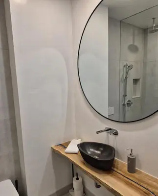 a bathroom with a black sink and a mirror at Gabby's Place Downtown Core in Toronto