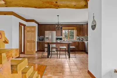a kitchen with a table and chairs in a room at Unique Log House by the Lake, Retreat with Spa Amenities near Presque'ile Provincial Park in Brighton