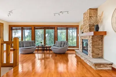 a living room with two chairs and a fireplace at Unique Log House by the Lake, Retreat with Spa Amenities near Presque'ile Provincial Park in Brighton