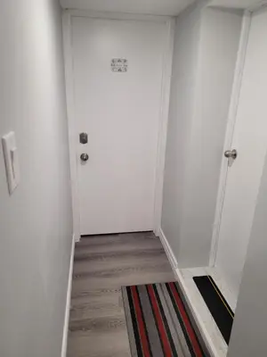 a hallway with two white doors and a rug at Guest House Basement - Master Bedrooms in Bayview Village in Toronto