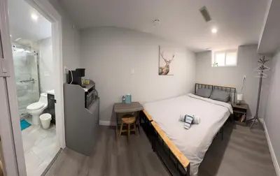 a small bedroom with a bed and a bathroom at Guest House Basement - Master Bedrooms in Bayview Village in Toronto