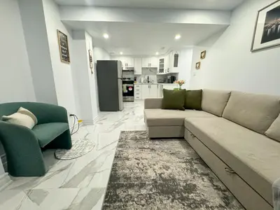 a living room with a couch and chairs and a kitchen at The Khan Villa in Whitby