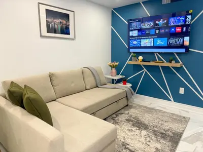 a living room with a couch and a flat screen tv at The Khan Villa in Whitby