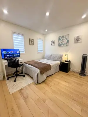 a bedroom with a bed and a desk and a television at The Khan Villa in Whitby