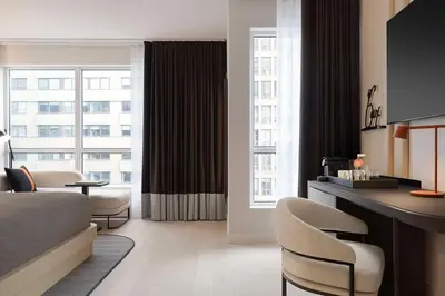 a hotel room with a bed and a table and chairs at Canopy By Hilton Toronto Yorkville in Toronto