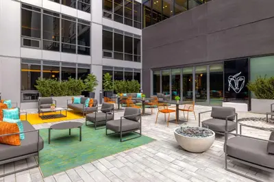 a courtyard with chairs and tables in front of a building at Canopy By Hilton Toronto Yorkville in Toronto