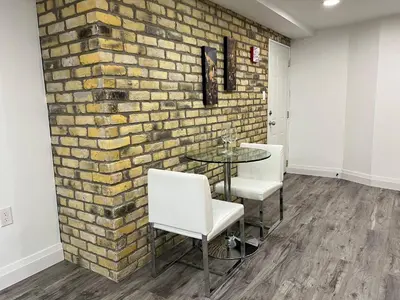 a brick wall in a room with a table and chairs at Adorable 1 Bedroom Suite With Kitchen Fireplace in Cambridge