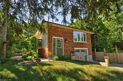 a brick house with a white garage in a yard at Adorable 1 Bedroom Suite With Kitchen Fireplace in Cambridge