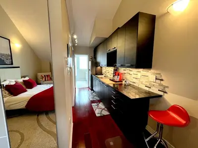 a room with a bed and a kitchen with a counter at Stunning Rooms in Townhouse across the Beach in Toronto