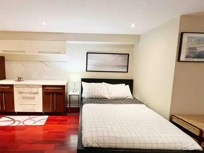 a room with two beds and a kitchen in it at Stunning Rooms in Townhouse across the Beach in Toronto