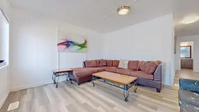 a living room with a couch and a table at Main Beach River Retreat - Wasaga Beach 1 - Main Strip - 93 Mosley St in Wasaga Beach